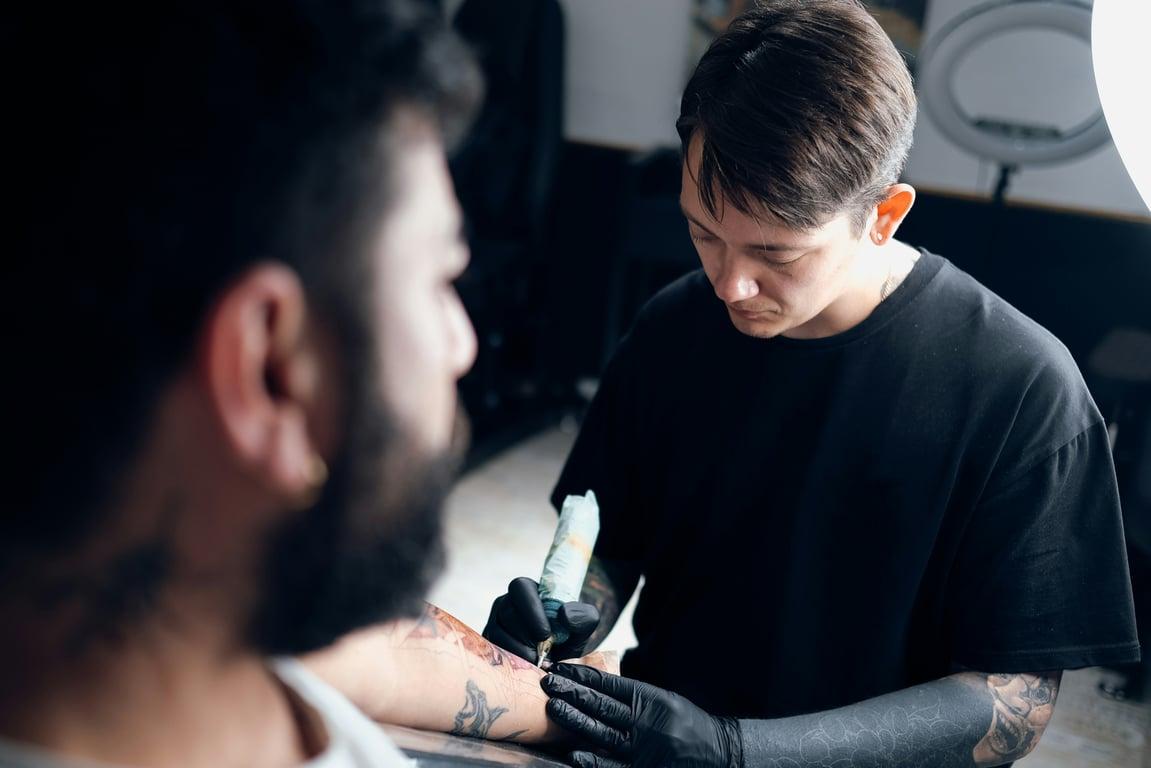 Tattoo artist working on a client